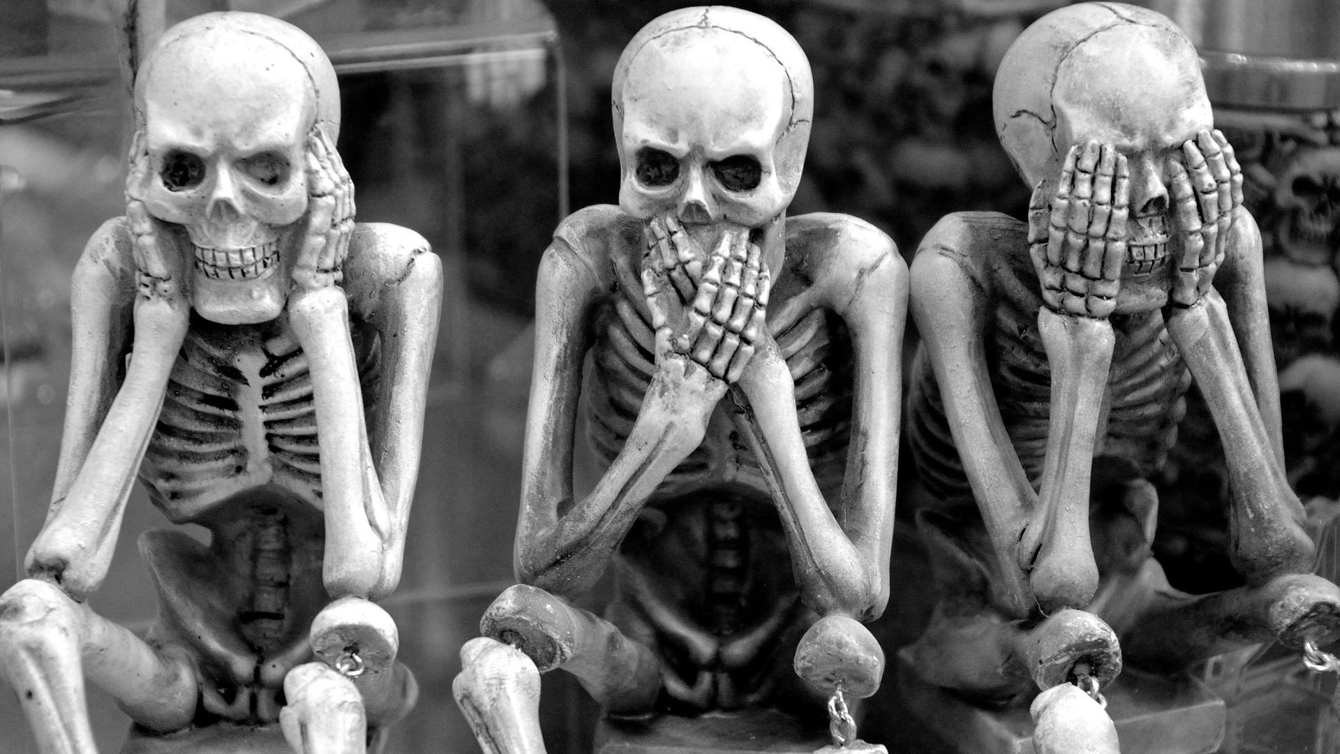 3 fake skeletons in black and white. Hear, speak and see no evil.