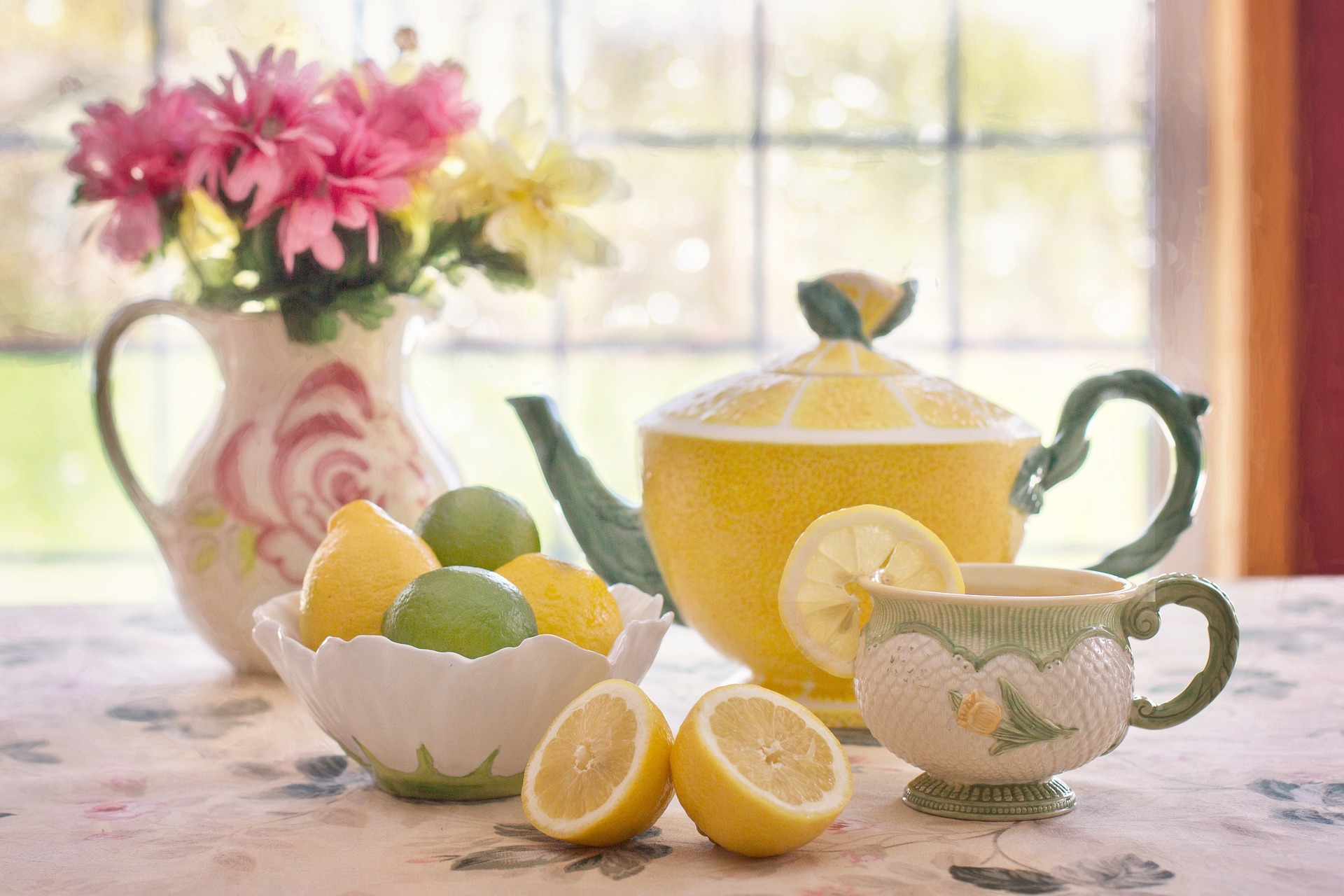 Teapot, teacups, lemon and lime on a tabletop