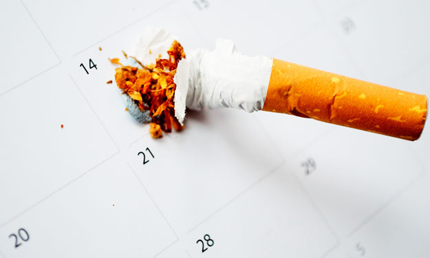 A Crushed Cigarette on Calender Marking a Quit Date.
