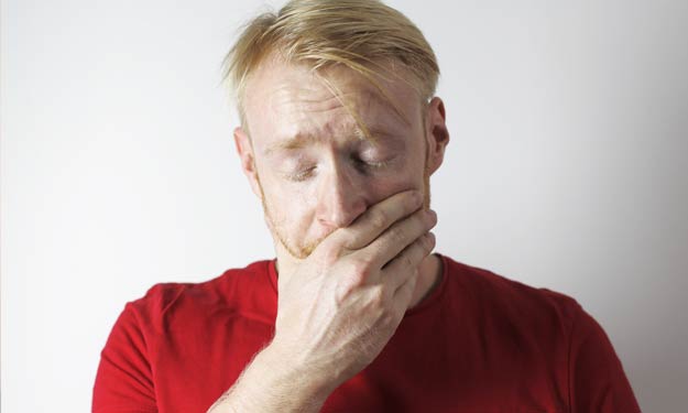 Man Holding Mouth has Sensitive Teeth. Home Remedies can Help.