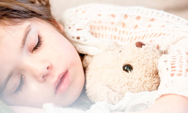 Young Girl with Cold Cuddled Up with Blankets Sleeping.
