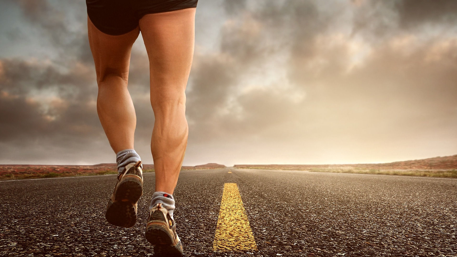 Man's bare legs jogging on pavement