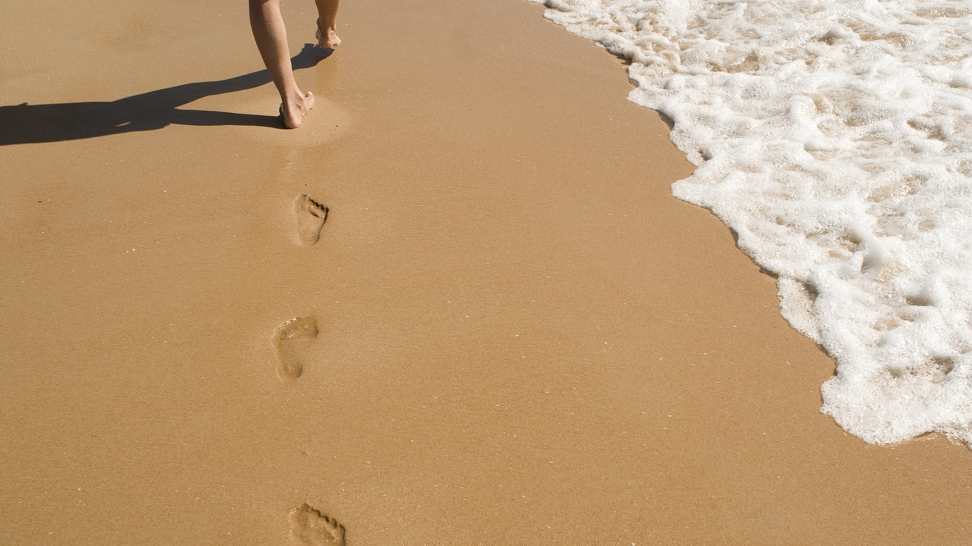 Bare feet walking on beach
