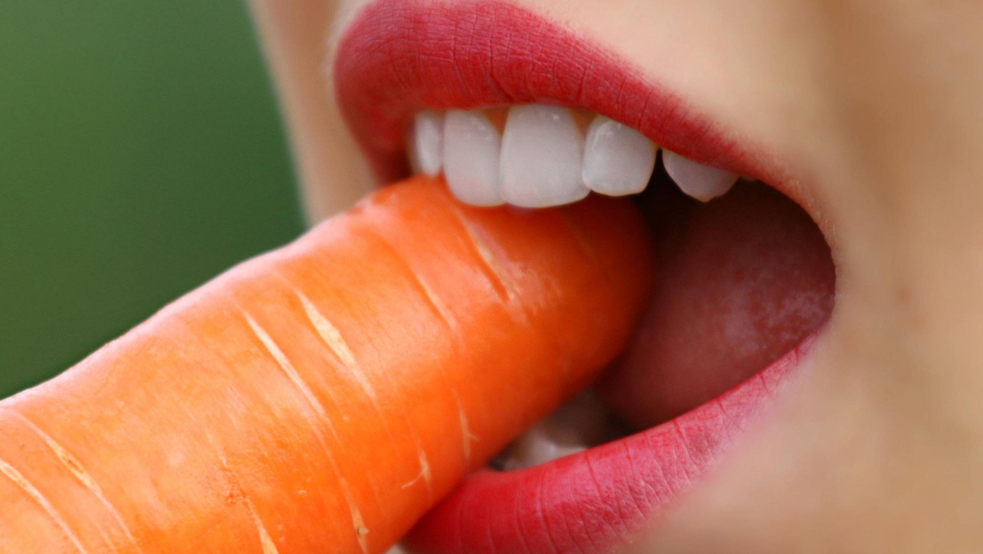 woman biting into a carrot