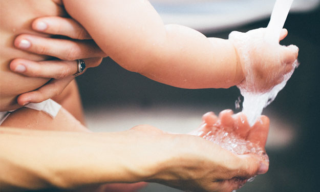 Couple Washing Hands and Showing Baby How to Wash.